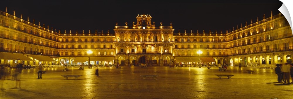 Wide angle photograph on a large wall hanging of Plaza Mayor Castile & Leon Salamanca, lit up at night, in Spain.