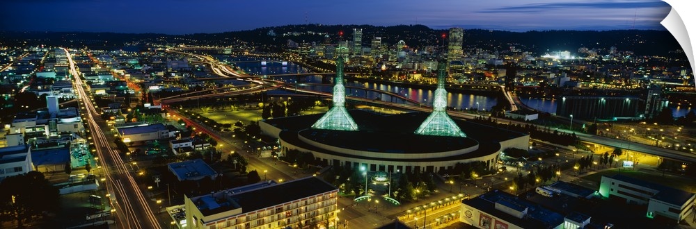 Oregon's most populous city lit up in the evening by the glowing lights of office buildings and traffic.