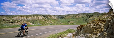 Rear view of a man cycling on a road, Badlands, Theodore Roosevelt National Park, North Dakota