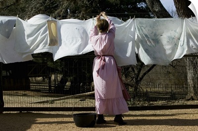 Rear view of a woman drying clothes on a clothesline, Lyndon B. Johnson National Historical Park, Johnson City, Texas