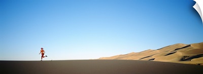Rear view of a woman running in the desert, Great Sand Dunes National Monument, Colorado