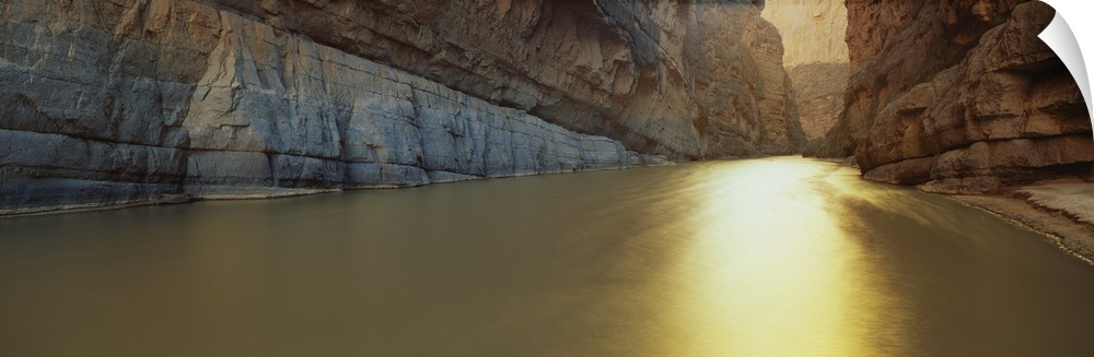 Panoramic picture looking down the Rio Grande River that cuts between immense cliffs.
