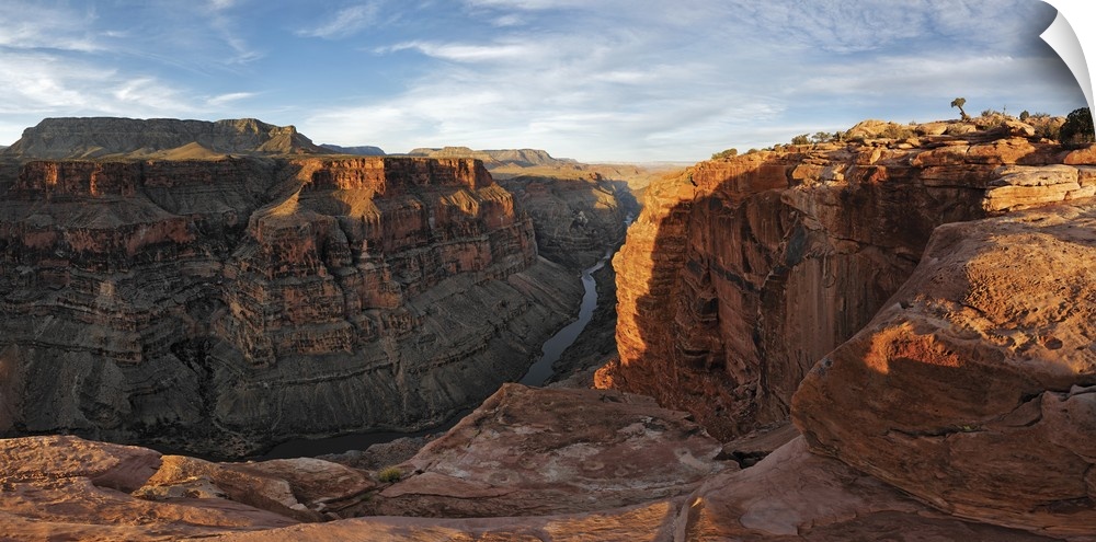 Large canvas photo of Grand Canyon cliffs draped in sunlight and shadows with a river running through them at the base.