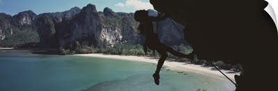 Rock Climber atKrabi, southern Thailand, with Railay beach in background