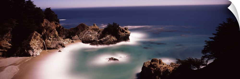 Larges rocks in the water and along the shore  of the Pacific Ocean in Big Sur, California.
