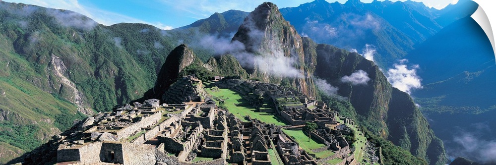 Ruins of an ancient civilization lay on a hill under a towering mountain in a valley in South America.