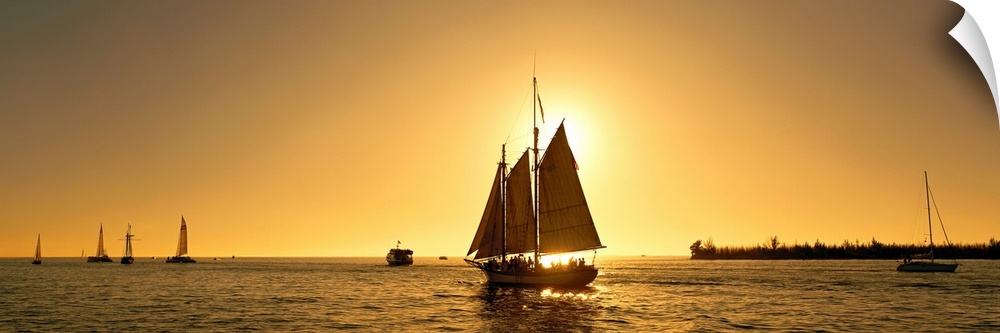A sail boat with multiple masts photographed at sunset it in the Florida Keys on panoramic wall art.