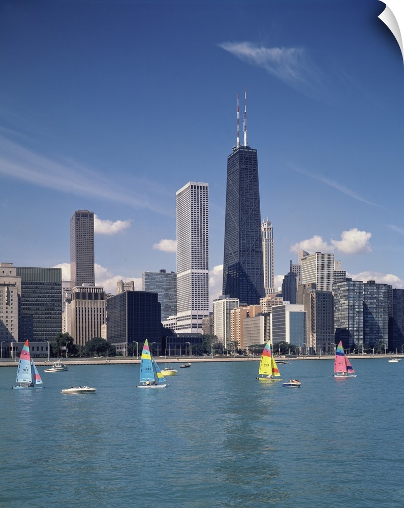 Vertical photograph of several boats on Lake Michigan in front of Chicago skyscrapers in Illinois.