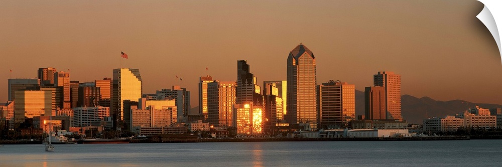 This is the San Diego skyline with the bay in front at sunset. The reflected light on the buildings is golden.