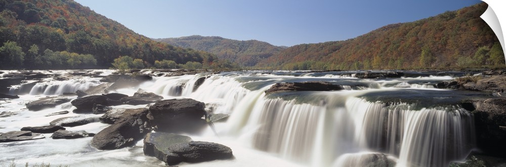 Panoramic image on canvas of long waterfalls with rolling mountains of fall foliage in the background.