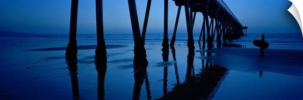 Big, landscape, panoramic photograph looking upward at an angle toward the Hermosa Beach Pier in California, at dusk. The ...
