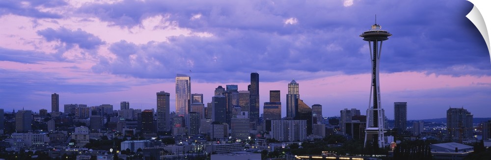 Panoramic cityscape photo of a major Pacific Northwest city with the Space Needle on the right.