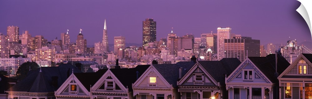The San Francisco skyline is illuminated at night and photographed in wide angle view from a distance.
