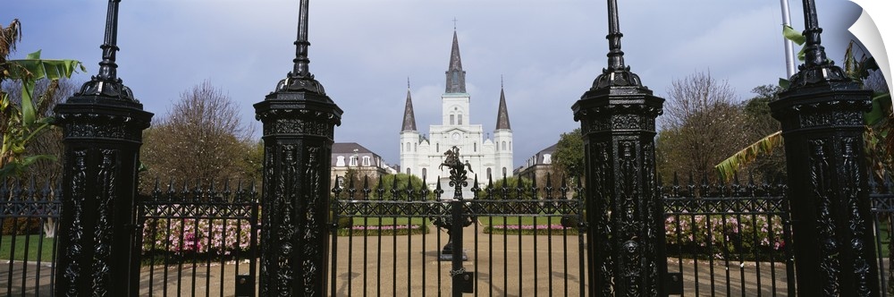Panoramic photo on canvas of a big house of worship that is seen through iron fences located in Louisiana.