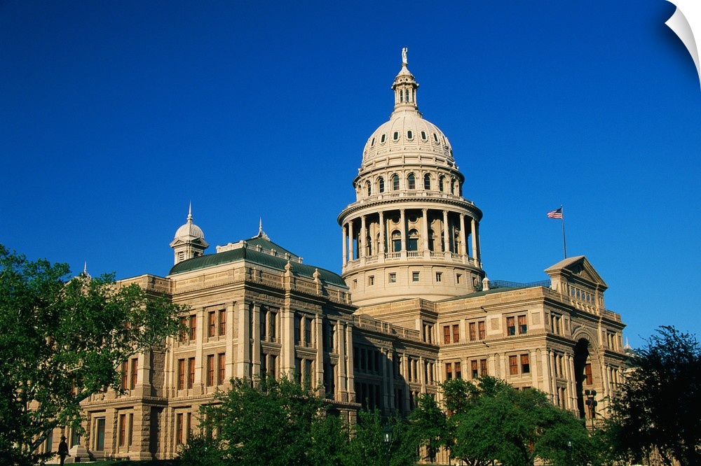 Landscape photograph of the state capitol building against a bright blue sky, in Austin, Texas.