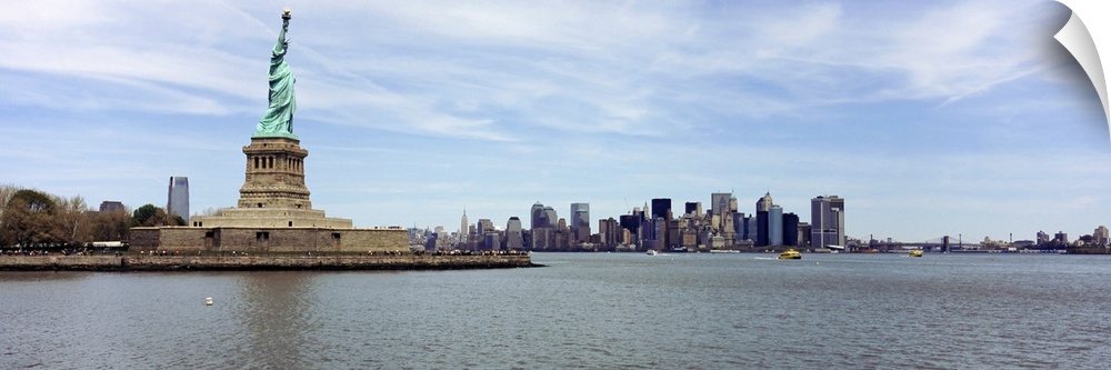 Big panoramic photo on canvas of the Statue of Liberty with the NYC cityscape in the distance.