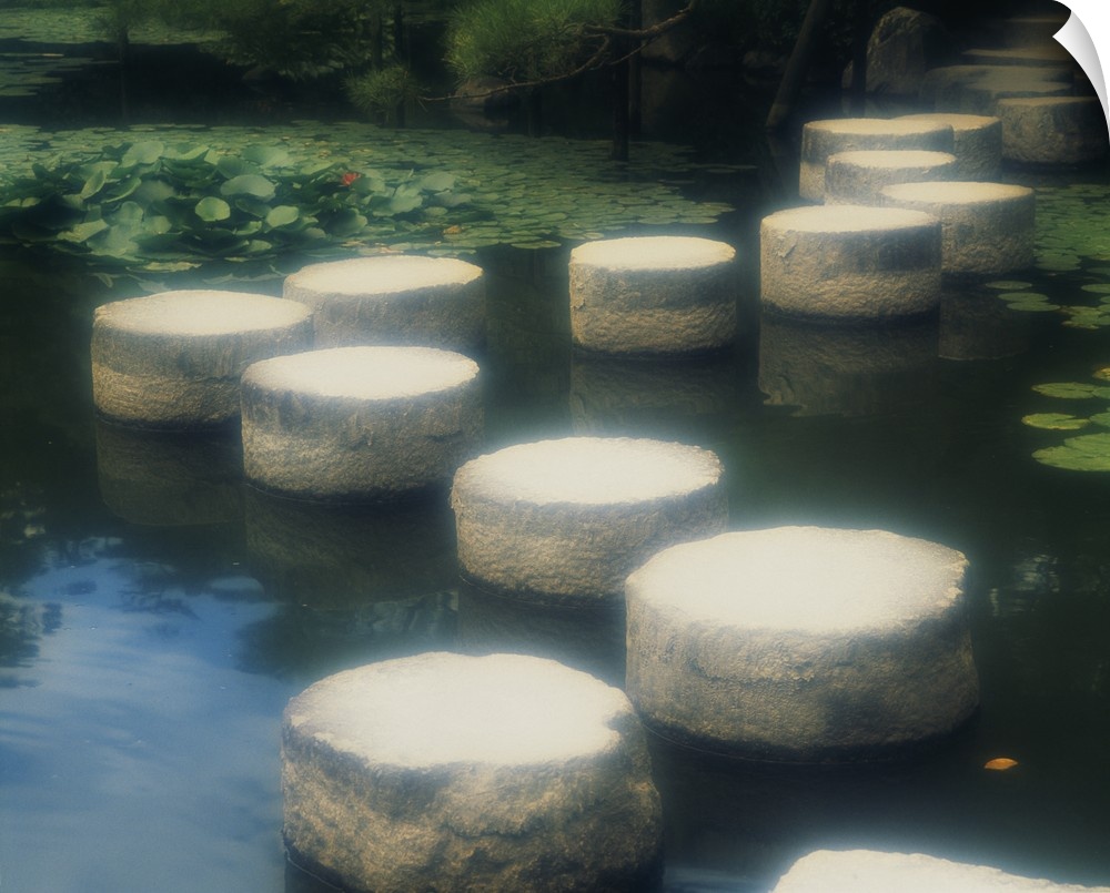 Large photo of a walkway of rocks across the water in a Japanese garden in Kyoto, Japan.