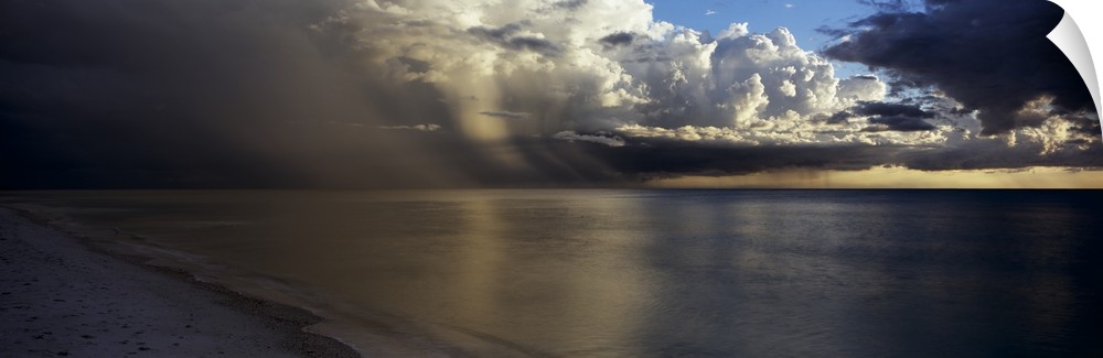 This is a panoramic photograph of clouds accumulating off shore before sunset.