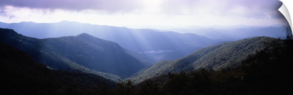 Wide angle photograph of the sun shining down on the Blue Ridge Mountains in North Carolina.