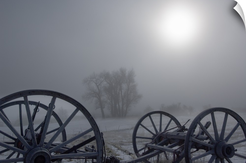 Sunlight through heavy fog, silhouetted wagon wheels, Gold Creek, Montana
