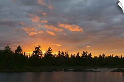 Sunset behind silhouetted forest, Lake Three, Boundary Waters Canoe Area Wilderness, Minnesota