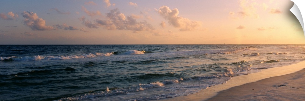 Panoramic photograph showcases waves of the Atlantic Ocean making their way to the Florida shore as the sun begins to set ...