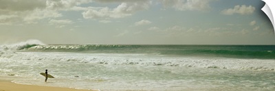 Surfer standing on the beach, North Shore, Oahu, Hawaii,