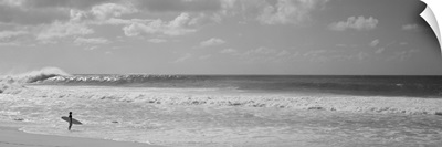 Surfer standing on the beach, North Shore, Oahu, Hawaii