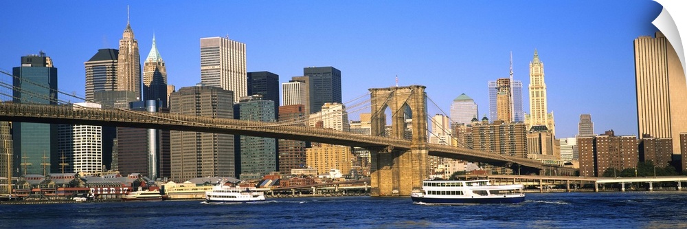 Suspension bridge across a river with skyscrapers in the background, Brooklyn Bridge, East River, Manhattan, New York City...