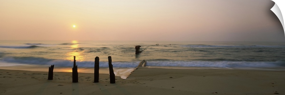 Posts and tide break on the beach at sunrise, Cape Hatteras National Seashore, North Carolina, USA