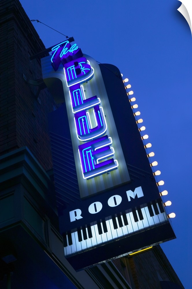 This is a vertical photograph of a neon sign outside popular musical venue.