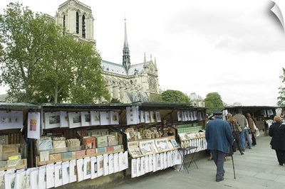 Tourists at the market stall with cathedral in the background, Notre Dame De Paris, Paris, Ile de France, France
