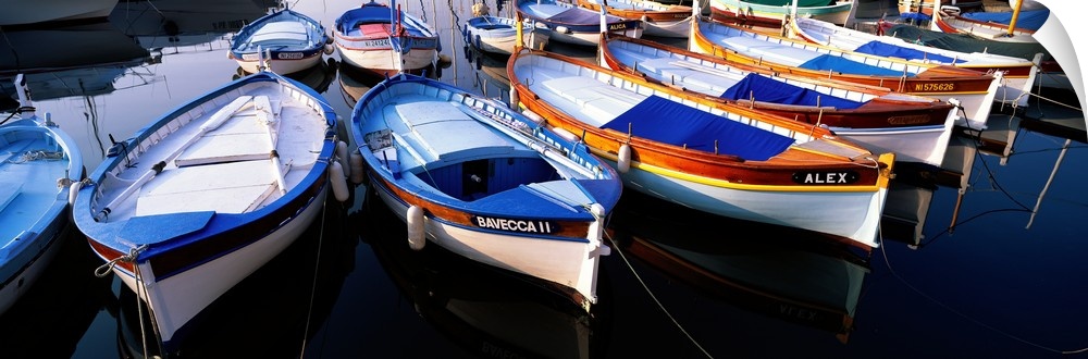Panoramic photograph of colorful boats strung up in rows.