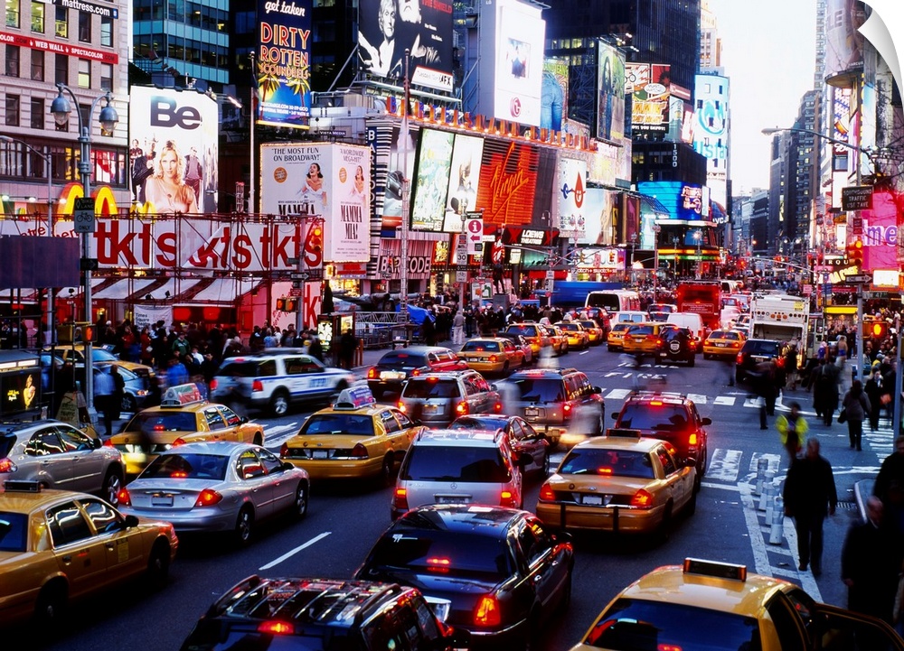 A landscape photograph of the chaotic city traffic crowded with taxi cabs, personal vehicles, and pedestrians.