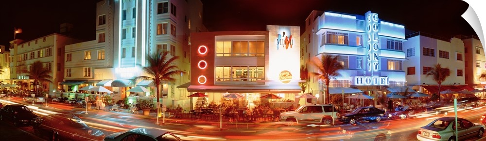 A panoramic view of the Art Deco buildings, neon lights and palm trees along Ocean Drive in Miami, Florida.
