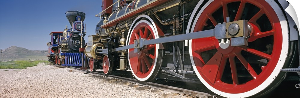 Panoramic photograph taken of the bottom of vintage trains as they ride on the tracks.