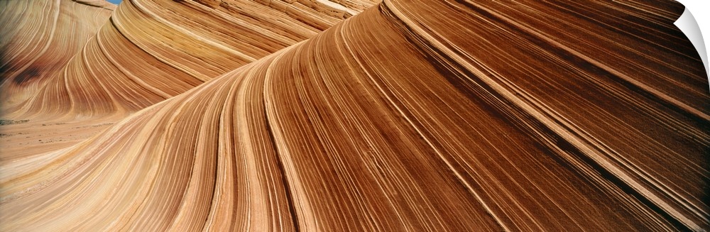 Desert cliff walls streaked with red rock lines flowing through a canyon.