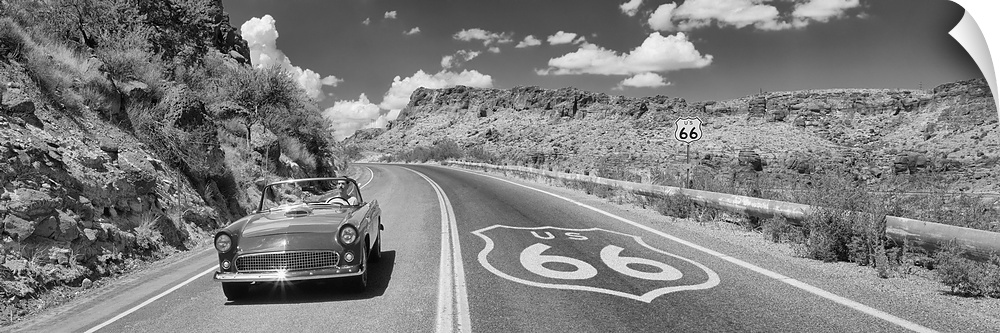 Panoramic photo of a retro car driving down a road on Route 66 in Arizona.