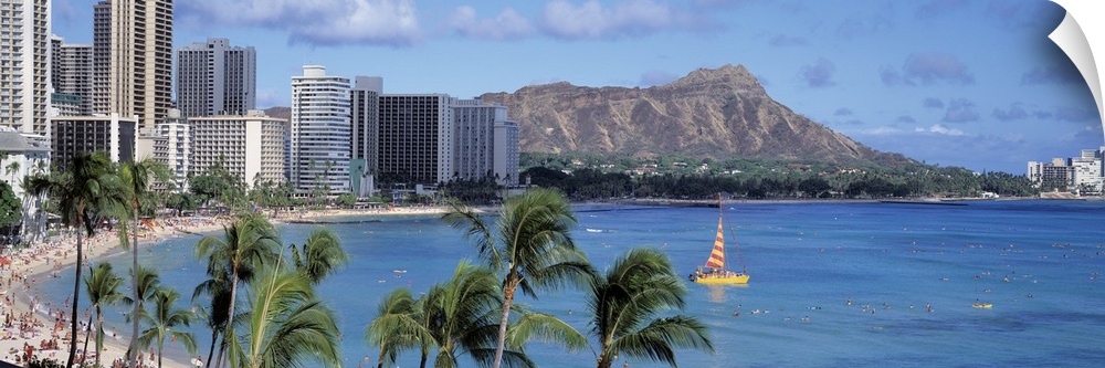 Large, panoramic photograph of tall buildings along the coast of Waikiki Beach in Honolulu, Hawaii.