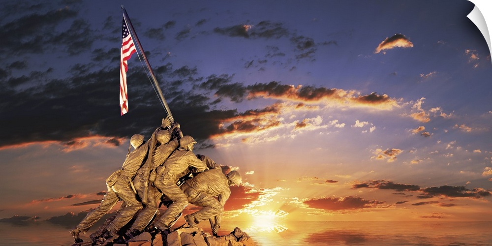 Composite image of a statue of American soldiers raising a flag on a rocky mount and the sun setting on the ocean's horizon.