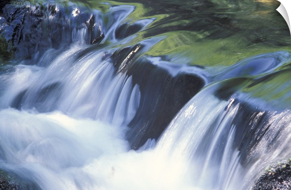 Up-close photograph of water flowing over huge rocks.