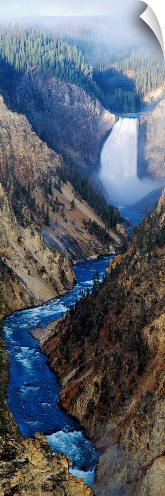 Giant panoramic artwork of a waterfall dumping water into a small river at the bottom of a canyon in Yellowstone National ...