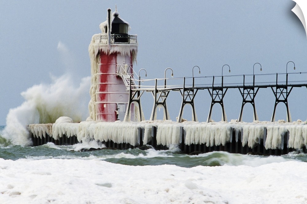 Wave crashing on snow-covered South Pier lighthouse, South Haven, Michigan