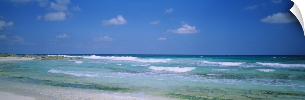 Panoramic image of waves crashing on the beach.