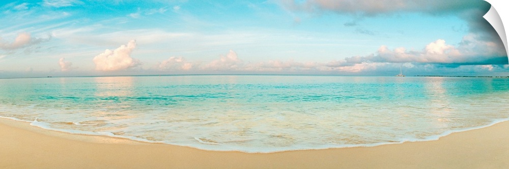 A wide angle panoramic wall hanging of a calm tropical ocean, waves on the beach, and cumulus clouds near the horizon.