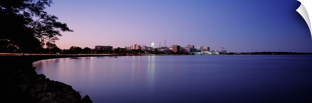 Panoramic photo print of buildings in Madison on the waterfront lit up at dusk.
