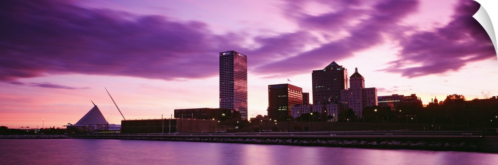 Taken from on the water at sunset this panoramic photograph shows city skyscrapers built along the waterfront.