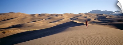 Woman running in the desert, Great Sand Dunes National Monument, Colorado