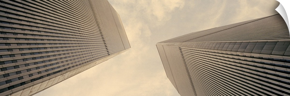 Panoramic photograph taken from the ground looking up at the nicknamed "Twin Towers" as they extend toward the daytime sky...