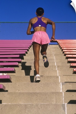 Athletic woman running up stairs